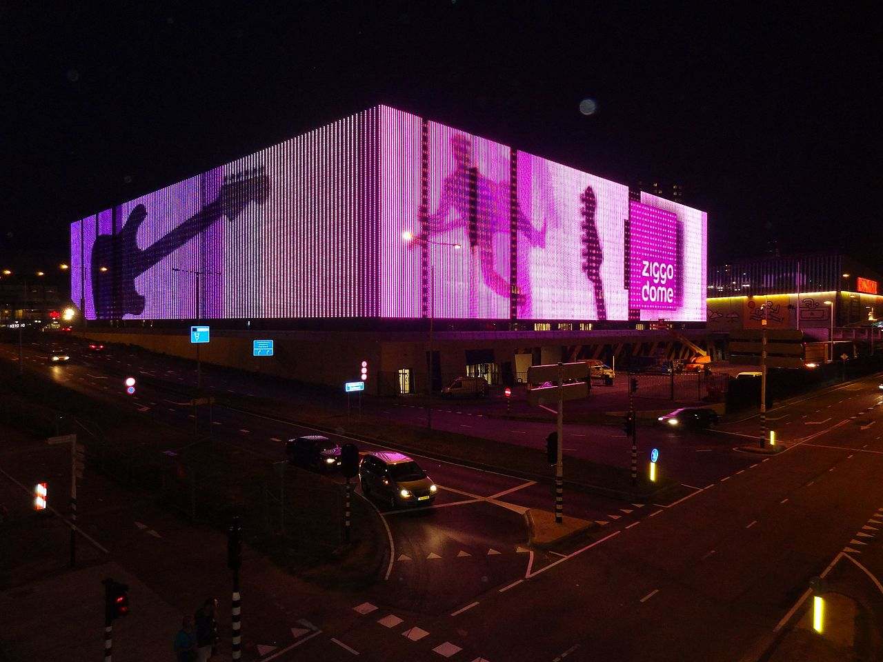 De verlichte gevel van de Ziggo Dome bij avond in Amsterdam-Zuidoost
